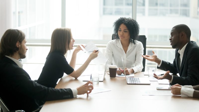 Diverse business partners arguing about bad contract at meeting in lawyers office, disgruntled clients disputing about scam fraud in law firm, cheated investors having claims dissatisfied with loan